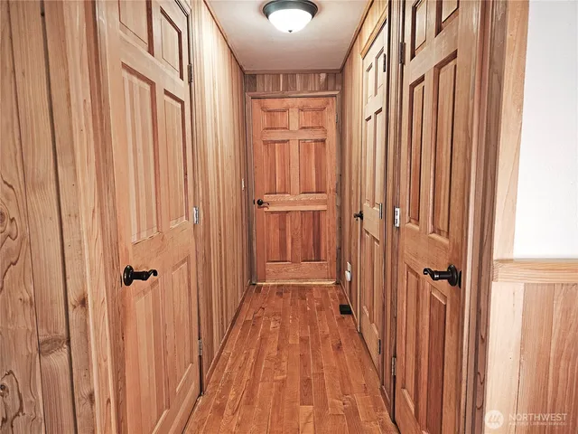 a view of a bedroom with wooden floor and fan
