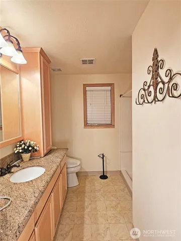 a bathroom with a granite countertop sink and a mirror