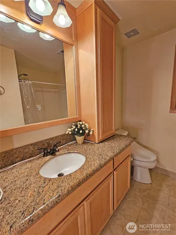 a bathroom with a toilet a sink and a window
