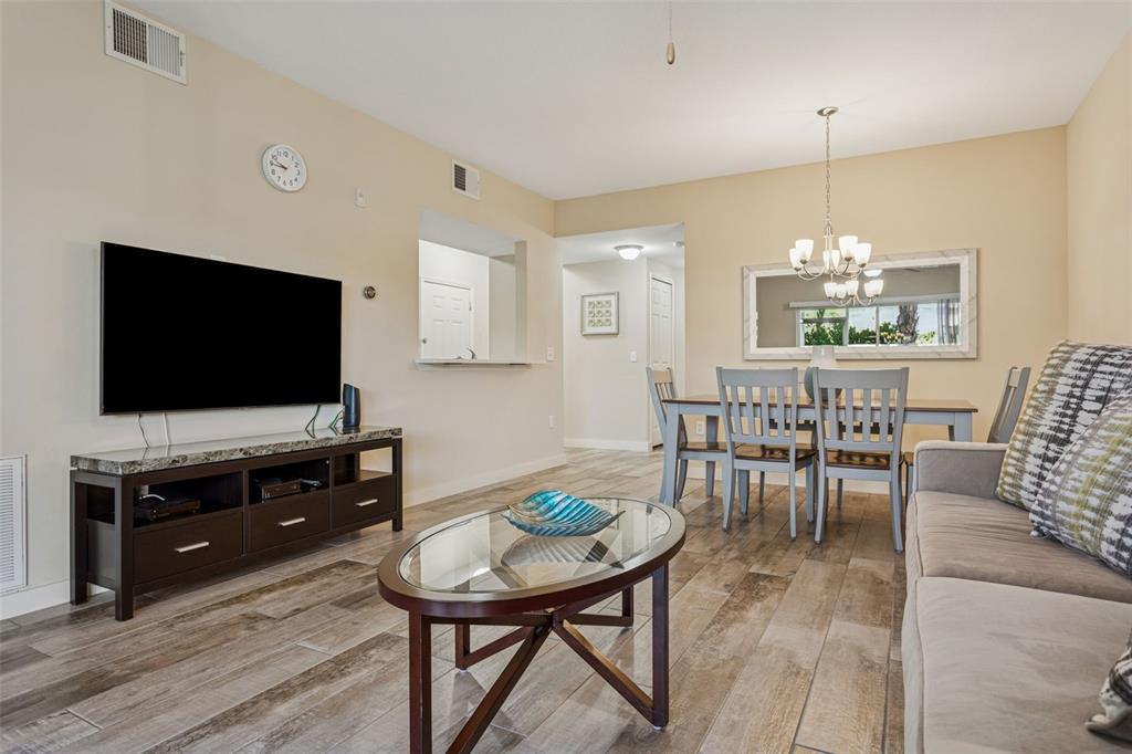 1231 Godavari Way, Unit 101 Wesley Chapel, FL 33543 - Photo 11 of 36 a living room with furniture and a flat screen tv