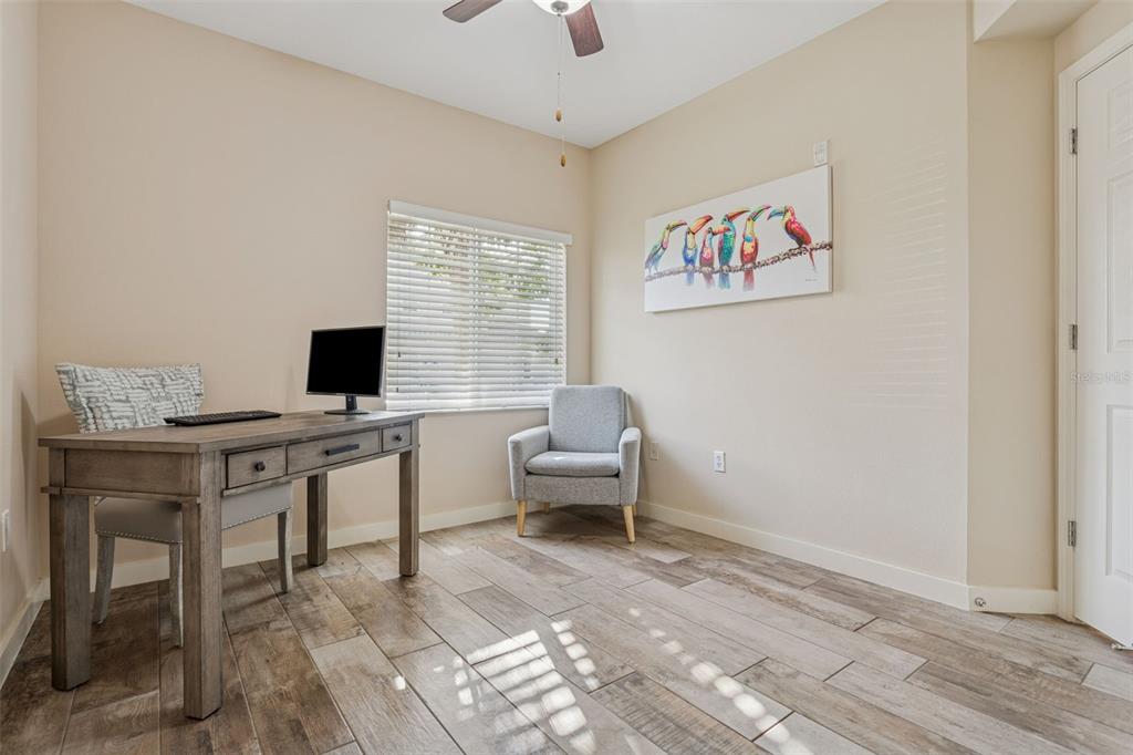 1231 Godavari Way, Unit 101 Wesley Chapel, FL 33543 - Photo 14 of 36 a work room with furniture and a flat screen tv