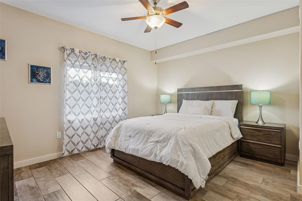 1231 Godavari Way, Unit 101 Wesley Chapel, FL 33543 - Photo 17 of 36 a bedroom with a bed and a lamp on the dresser