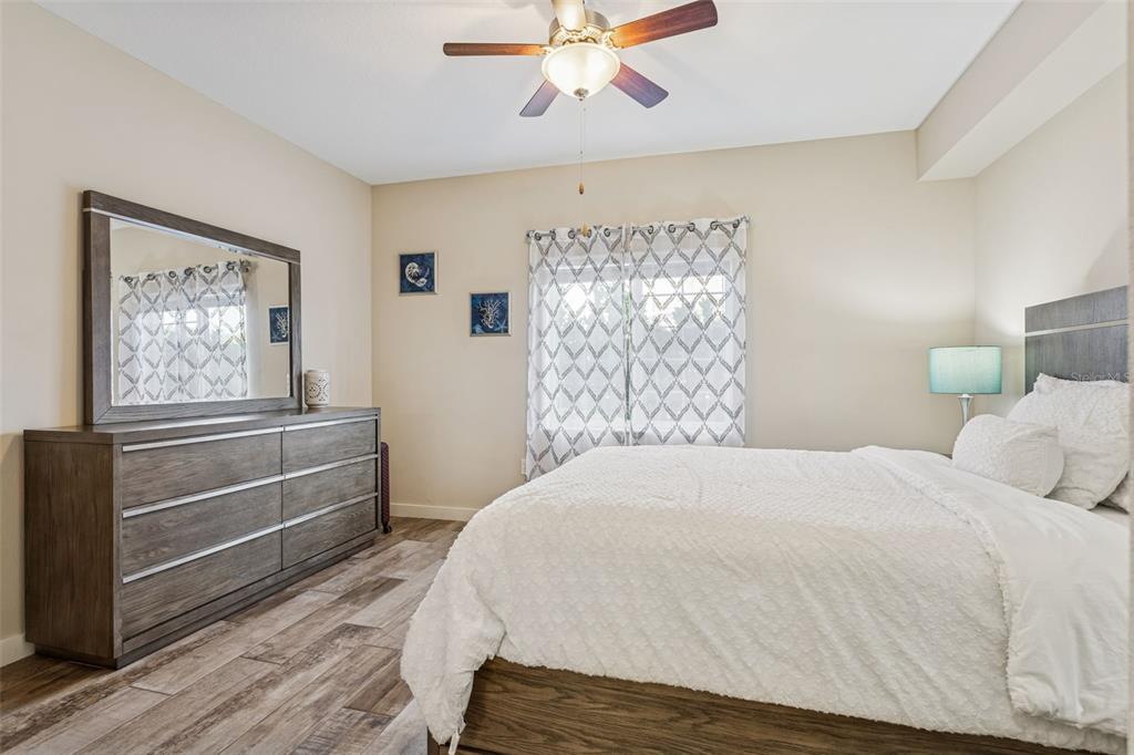 1231 Godavari Way, Unit 101 Wesley Chapel, FL 33543 - Photo 19 of 36 a bedroom with a bed and a chandelier