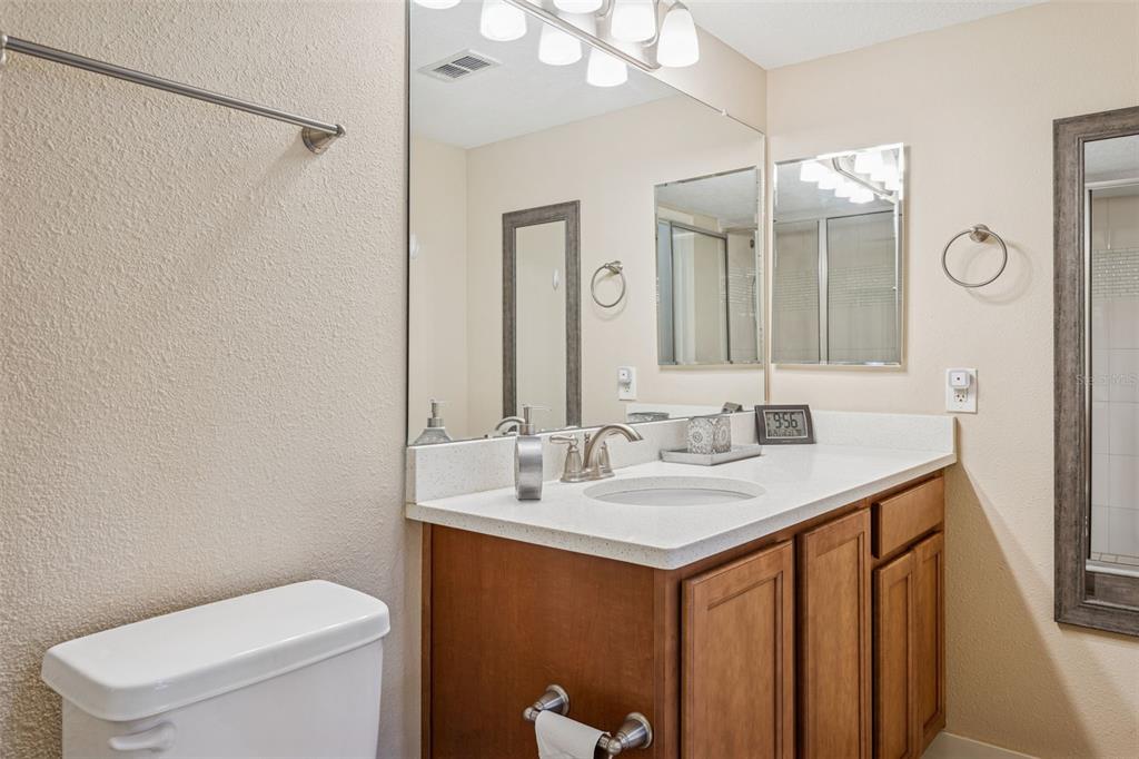 1231 Godavari Way, Unit 101 Wesley Chapel, FL 33543 - Photo 20 of 36 a bathroom with a sink a toilet and mirror