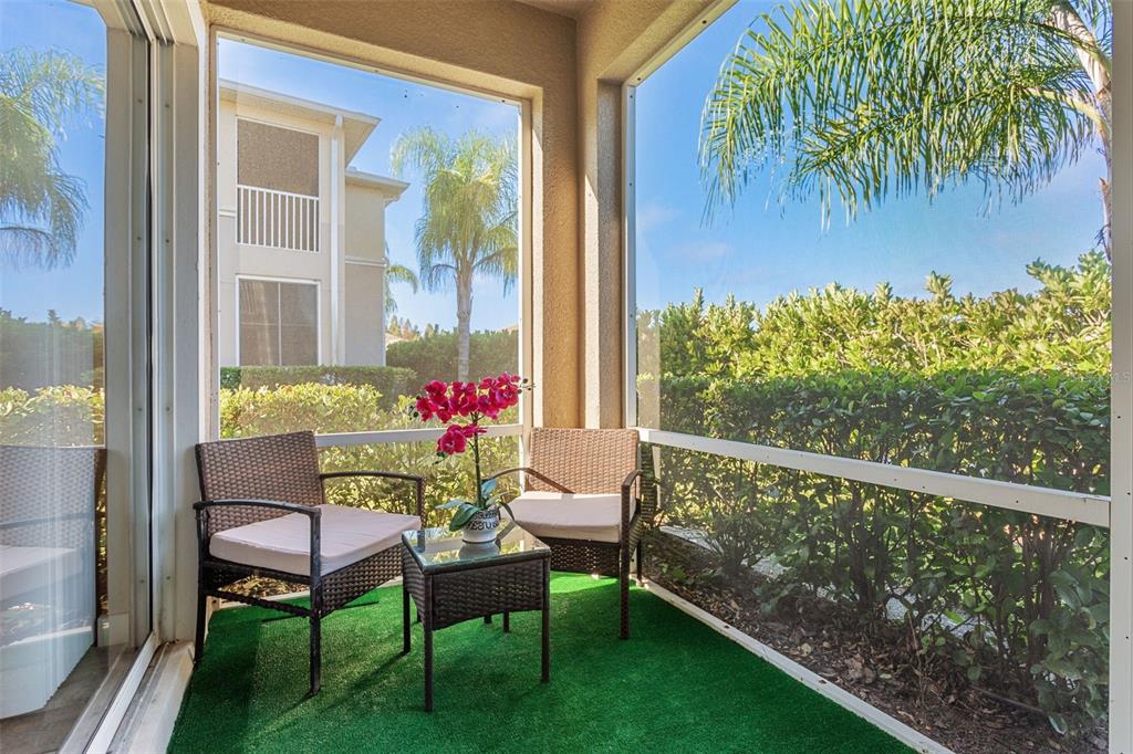 1231 Godavari Way, Unit 101 Wesley Chapel, FL 33543 - Photo 23 of 36 a balcony with wooden floor and a garden