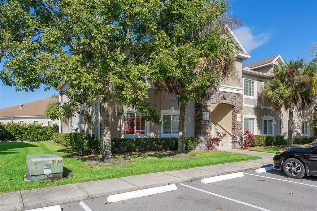1231 Godavari Way, Unit 101 Wesley Chapel, FL 33543 - Photo 3 of 36 a front view of a house with a garden and tree