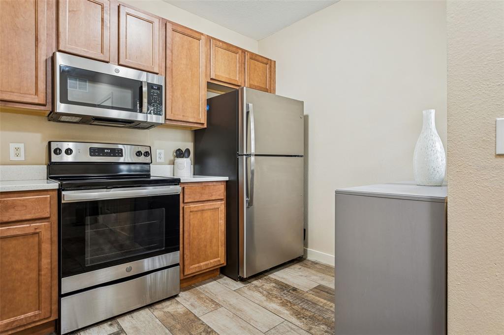 1231 Godavari Way, Unit 101 Wesley Chapel, FL 33543 - Photo 7 of 36 a kitchen with a refrigerator stove and microwave