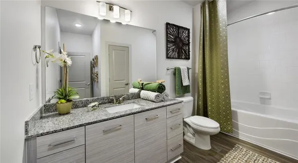 a bathroom with a granite countertop sink toilet and shower