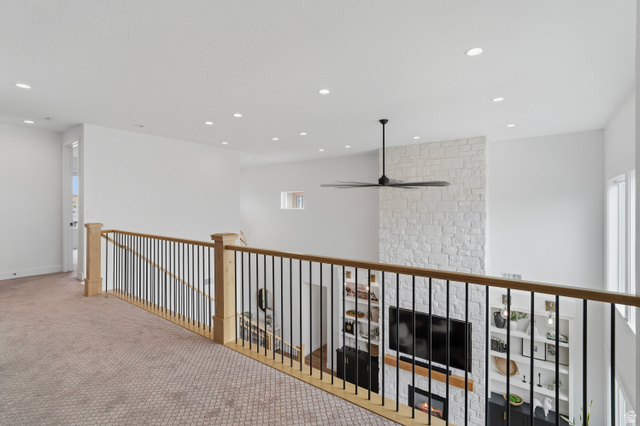 2278 Tawny Ridge Circle St. George, UT 84790 - Photo 37 of 61 Upper-level hallway with patterned carpet flooring, natural wood handrails, and black metal balusters.