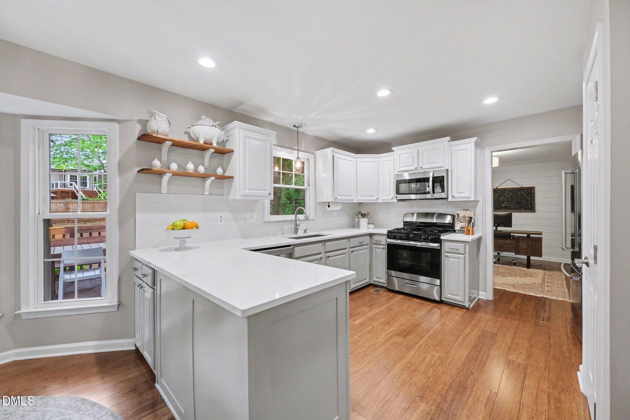 103 Leckford Way Cary, NC 27513 - Photo 12 of 49 a kitchen with a refrigerator a stove top oven and wooden floor
