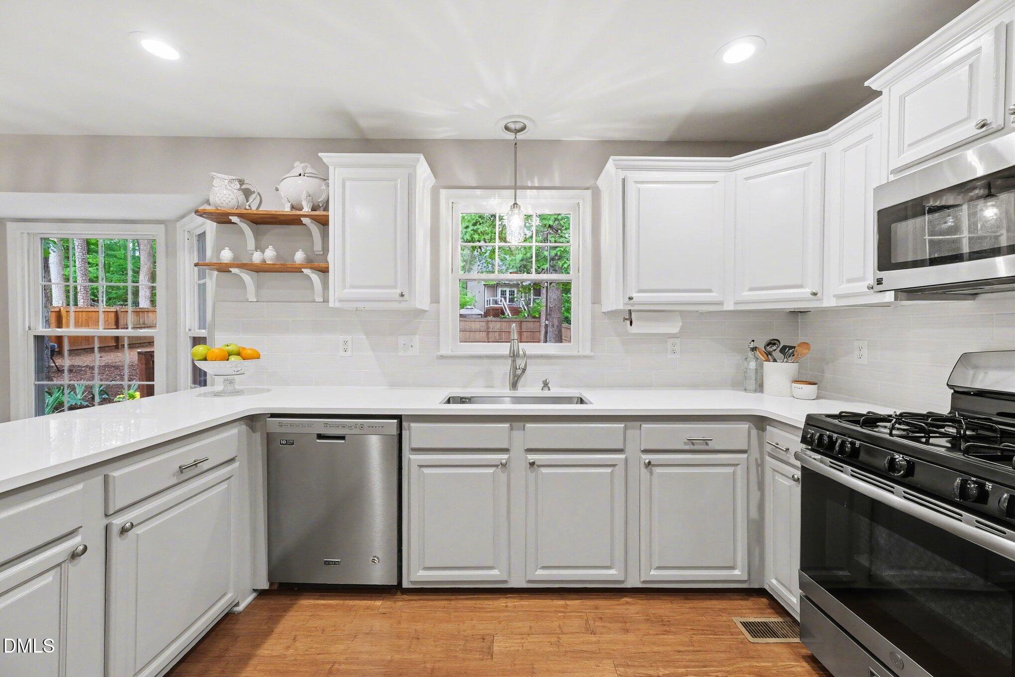 103 Leckford Way Cary, NC 27513 - Photo 13 of 49 a kitchen with white cabinets and appliances