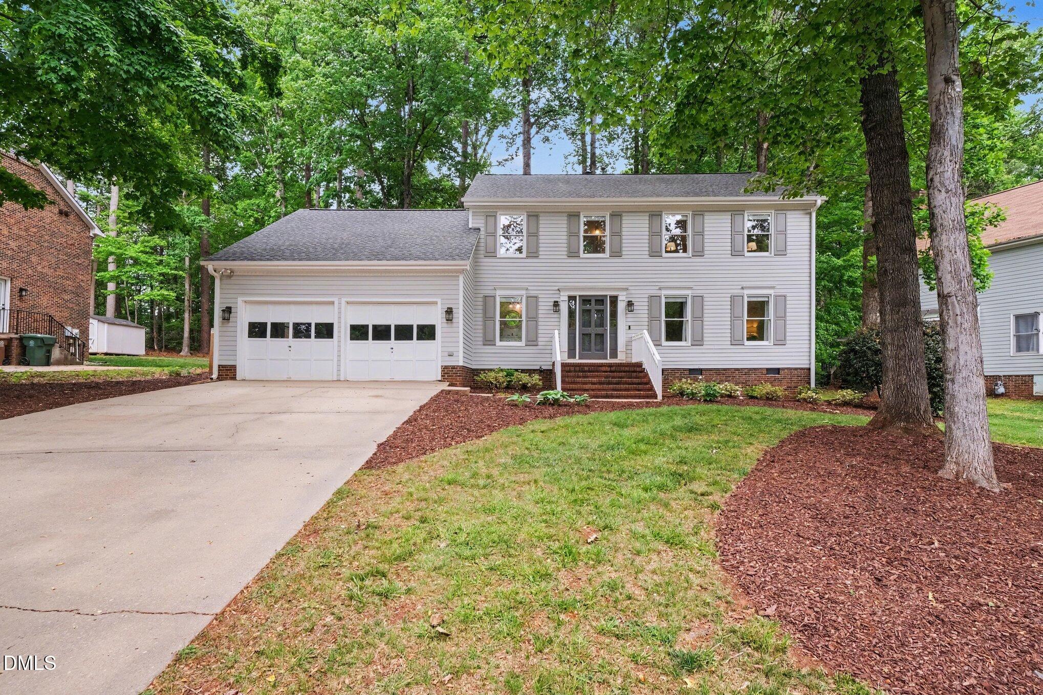 103 Leckford Way Cary, NC 27513 - Photo 2 of 49 a view of a white house with a big yard plants and large trees