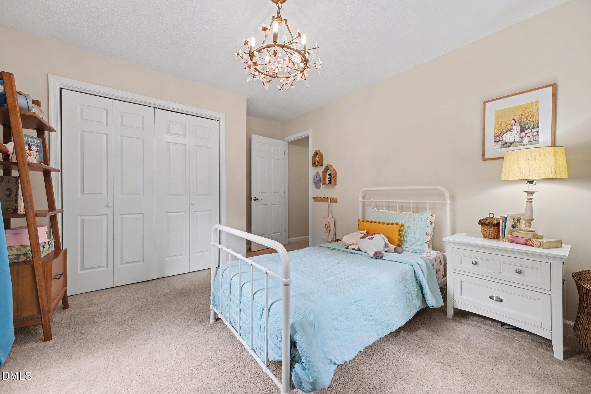 103 Leckford Way Cary, NC 27513 - Photo 24 of 49 a bedroom with a bed and a chandelier