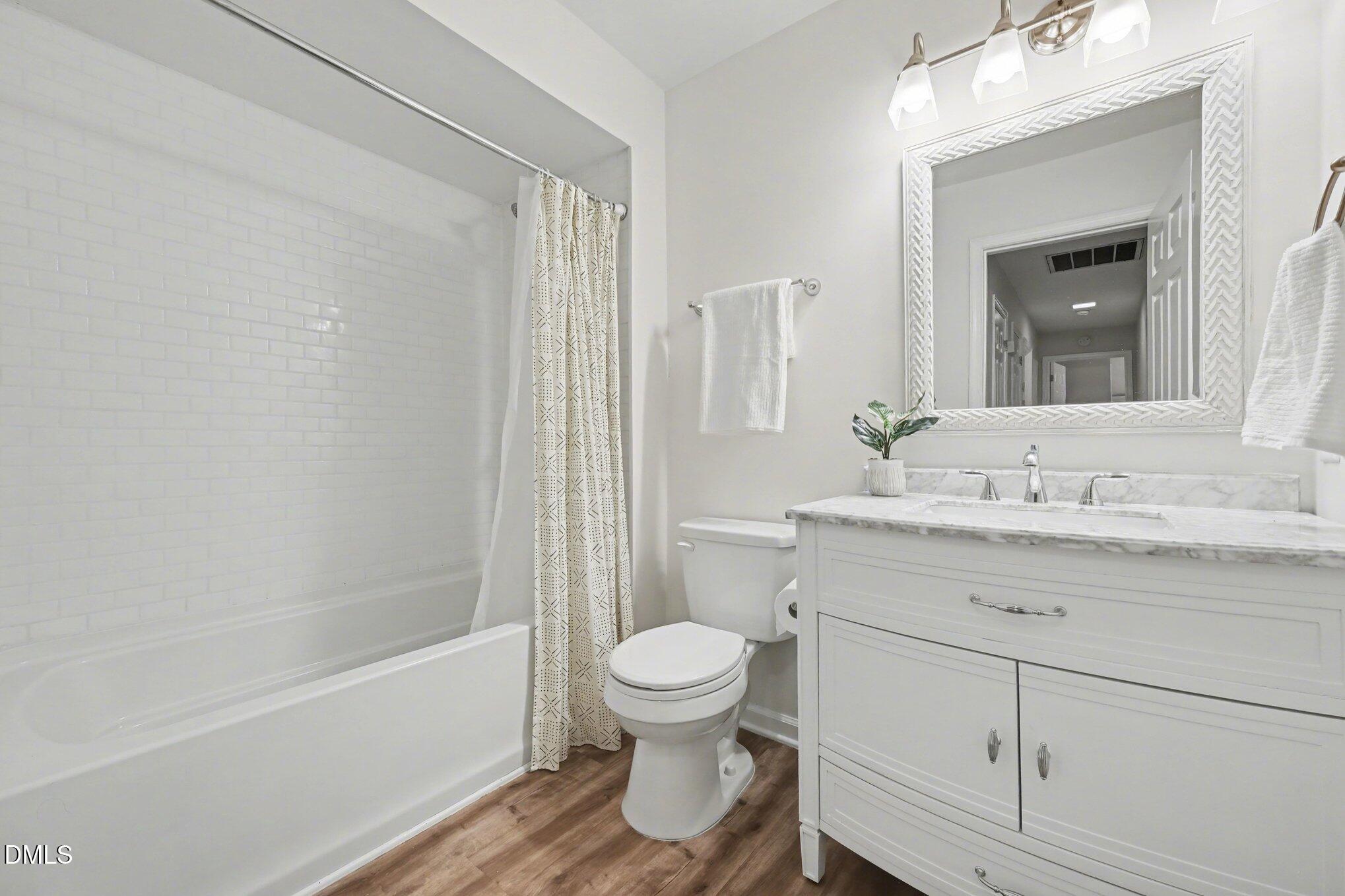 103 Leckford Way Cary, NC 27513 - Photo 28 of 49 a bathroom with a sink a toilet and a large mirror