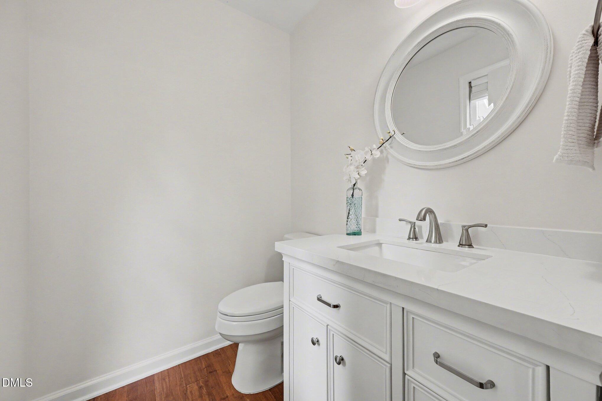103 Leckford Way Cary, NC 27513 - Photo 30 of 49 a bathroom with a toilet sink vanity and mirror