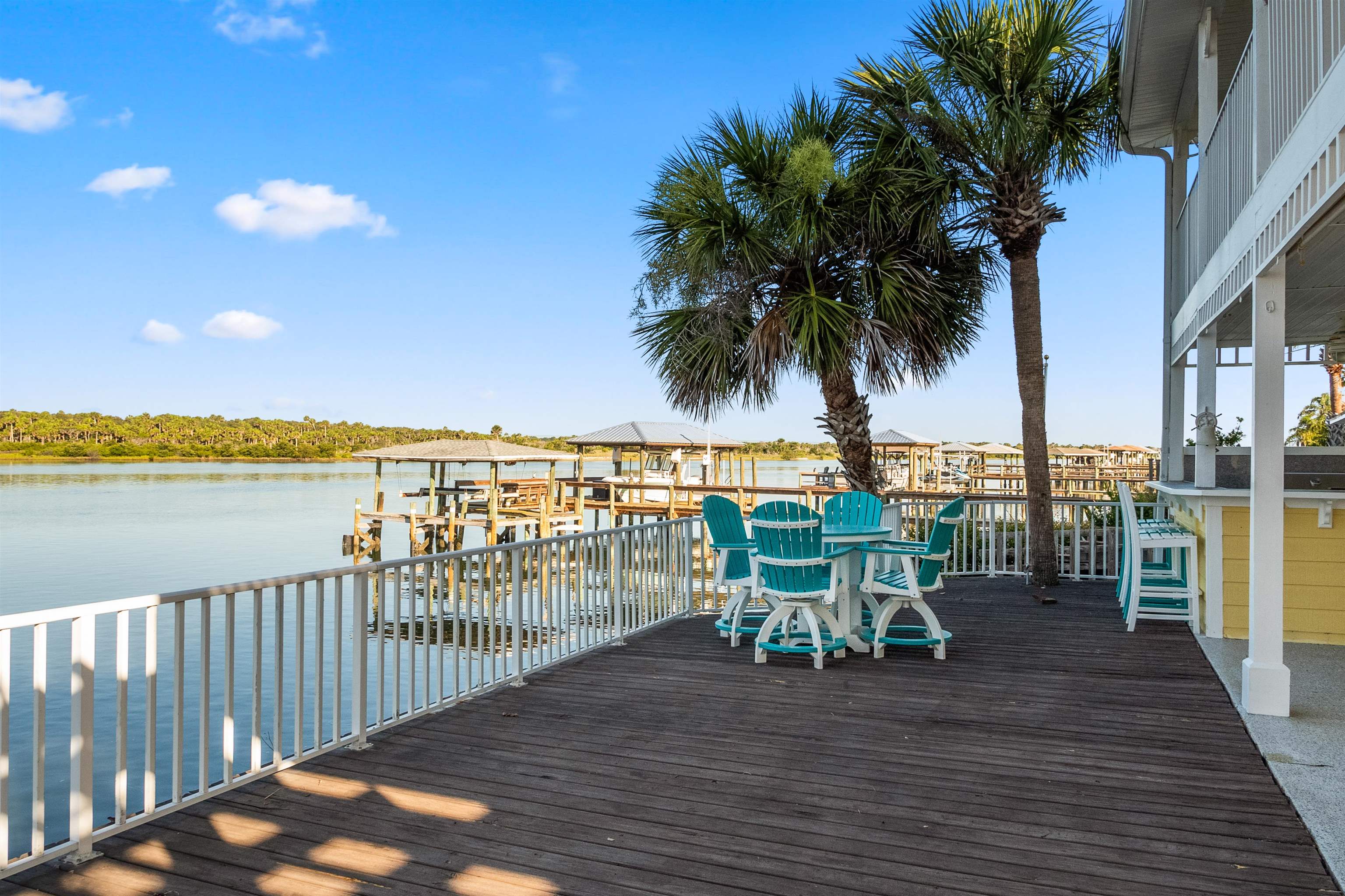 9277 July Lane St. Augustine, FL 32080 - Photo 23 of 72 a view of a chair and table on the wooden deck