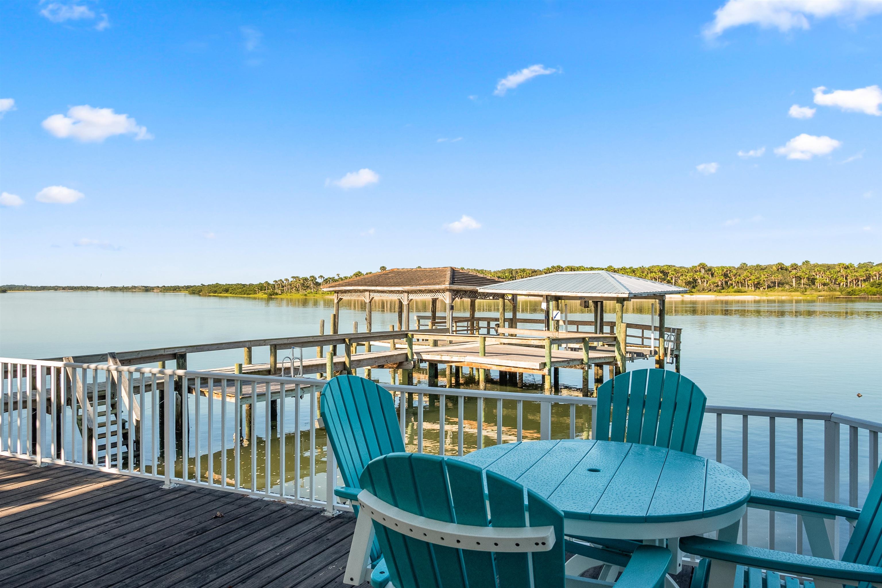 9277 July Lane St. Augustine, FL 32080 - Photo 26 of 72 a view of a balcony with wooden chairs and floor to ceiling window