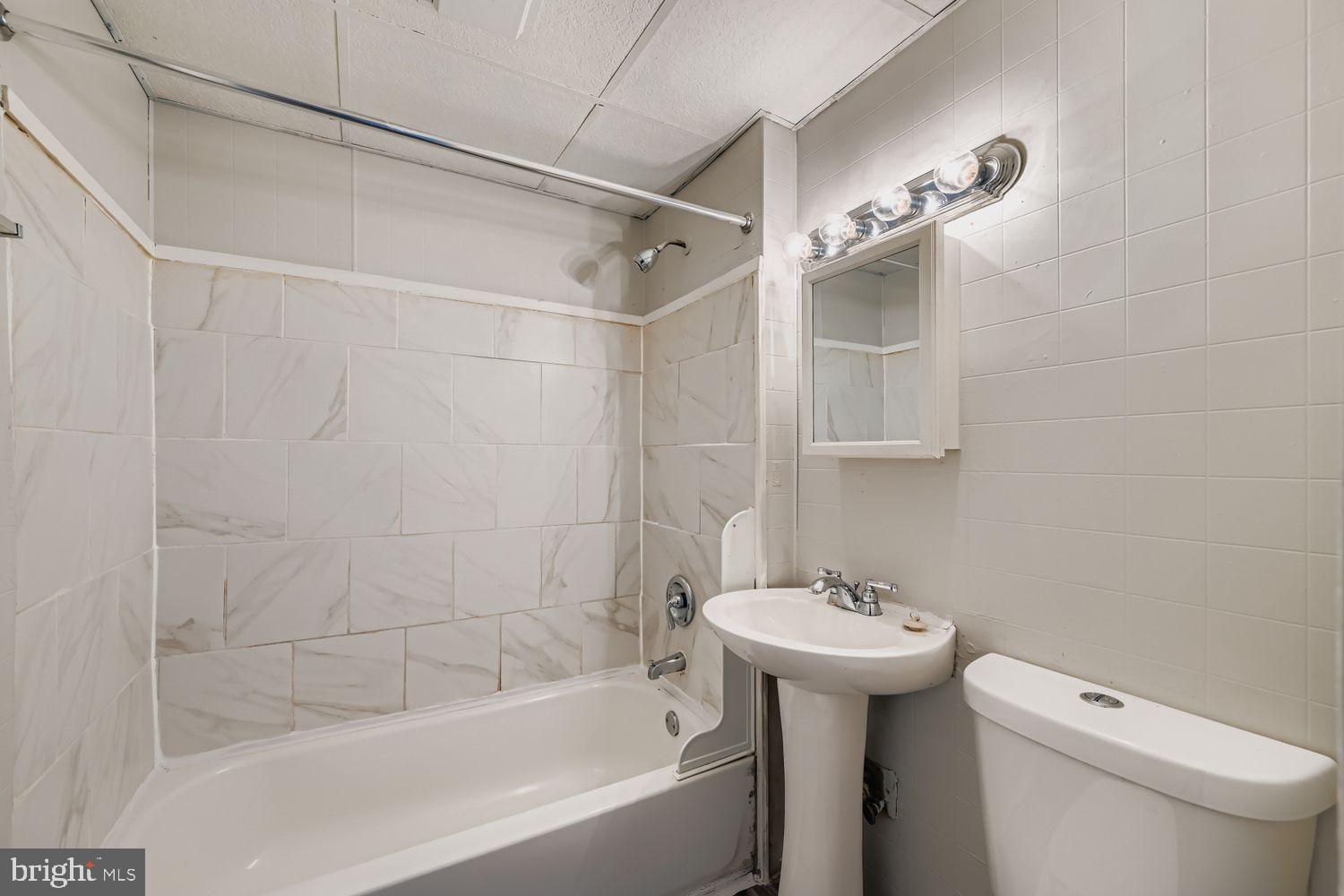 415 Cambria Street Baltimore, MD 21225 - Photo 11 of 17 a bathroom with a sink a toilet and shower