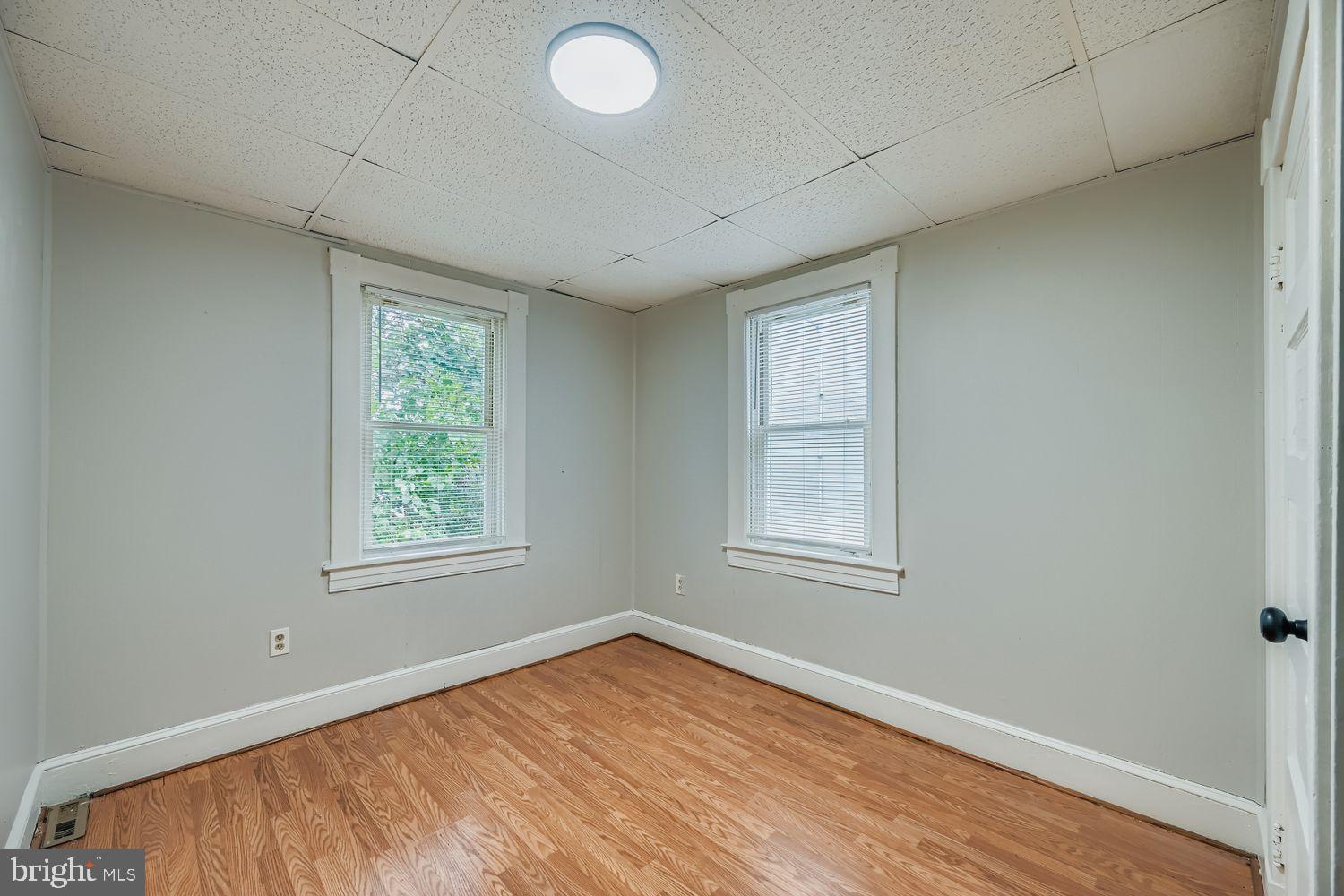 415 Cambria Street Baltimore, MD 21225 - Photo 12 of 17 an empty room with wooden floor and windows