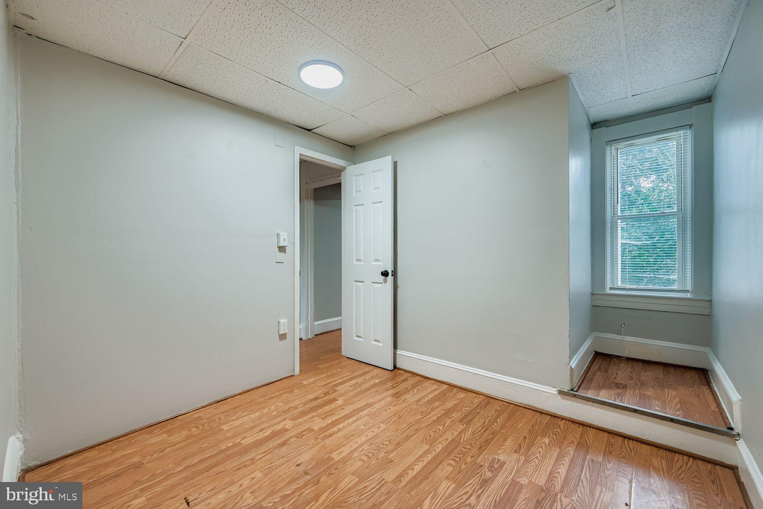 415 Cambria Street Baltimore, MD 21225 - Photo 13 of 17 an empty room with wooden floor and windows