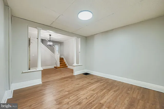a view of empty room with wooden floor