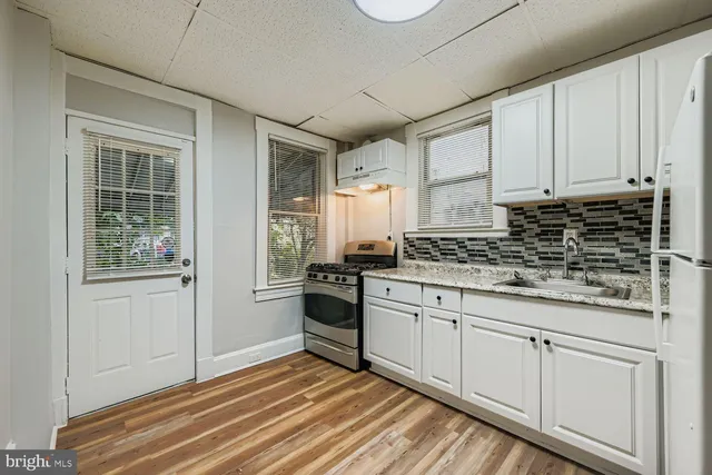 a kitchen with granite countertop white cabinets and white appliances