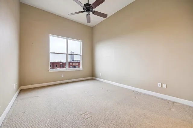 an empty room with windows and fan