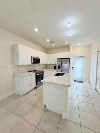 a kitchen with a stove a sink and a refrigerator