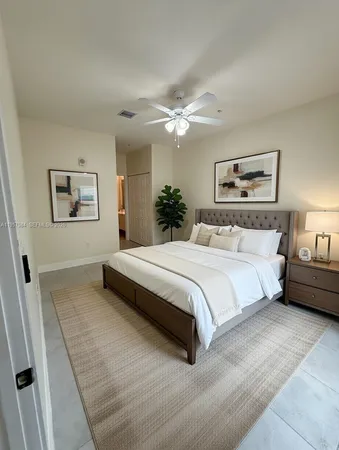 a bedroom with a large bed and a chandelier