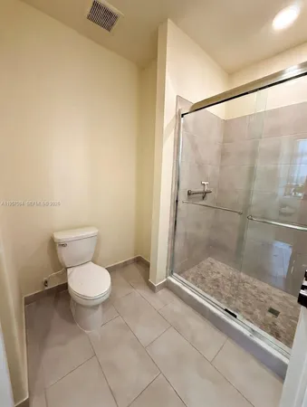 a bathroom with a granite countertop sink a toilet and a shower