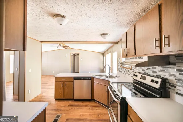 a kitchen with a refrigerator a stove a sink and a microwave