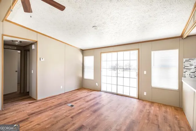 a view of a room with a stylish ceiling fan and entryway