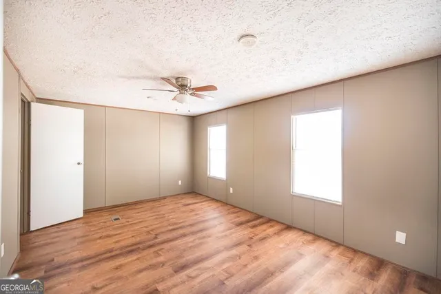 a view of a big room with wooden floor and a ceiling fan in a room