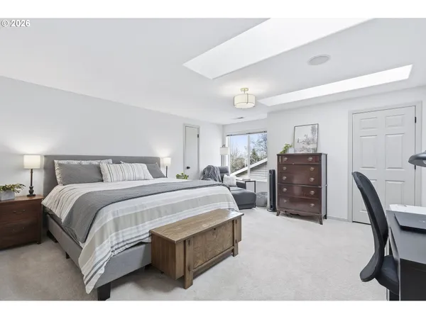 a spacious bedroom with a bed a desk and chair