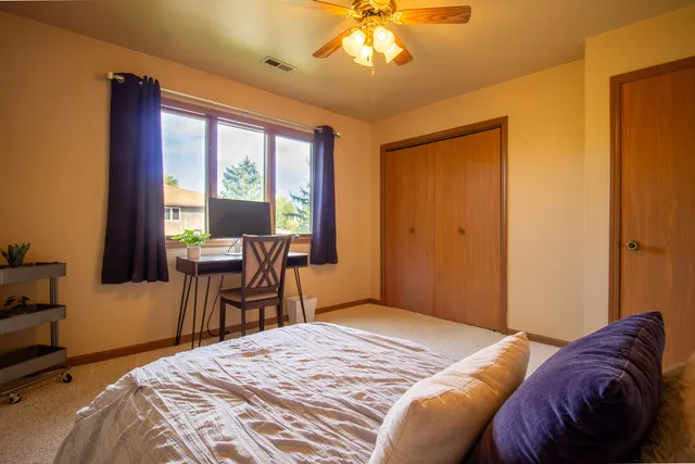 a bedroom with a bed and a large window
