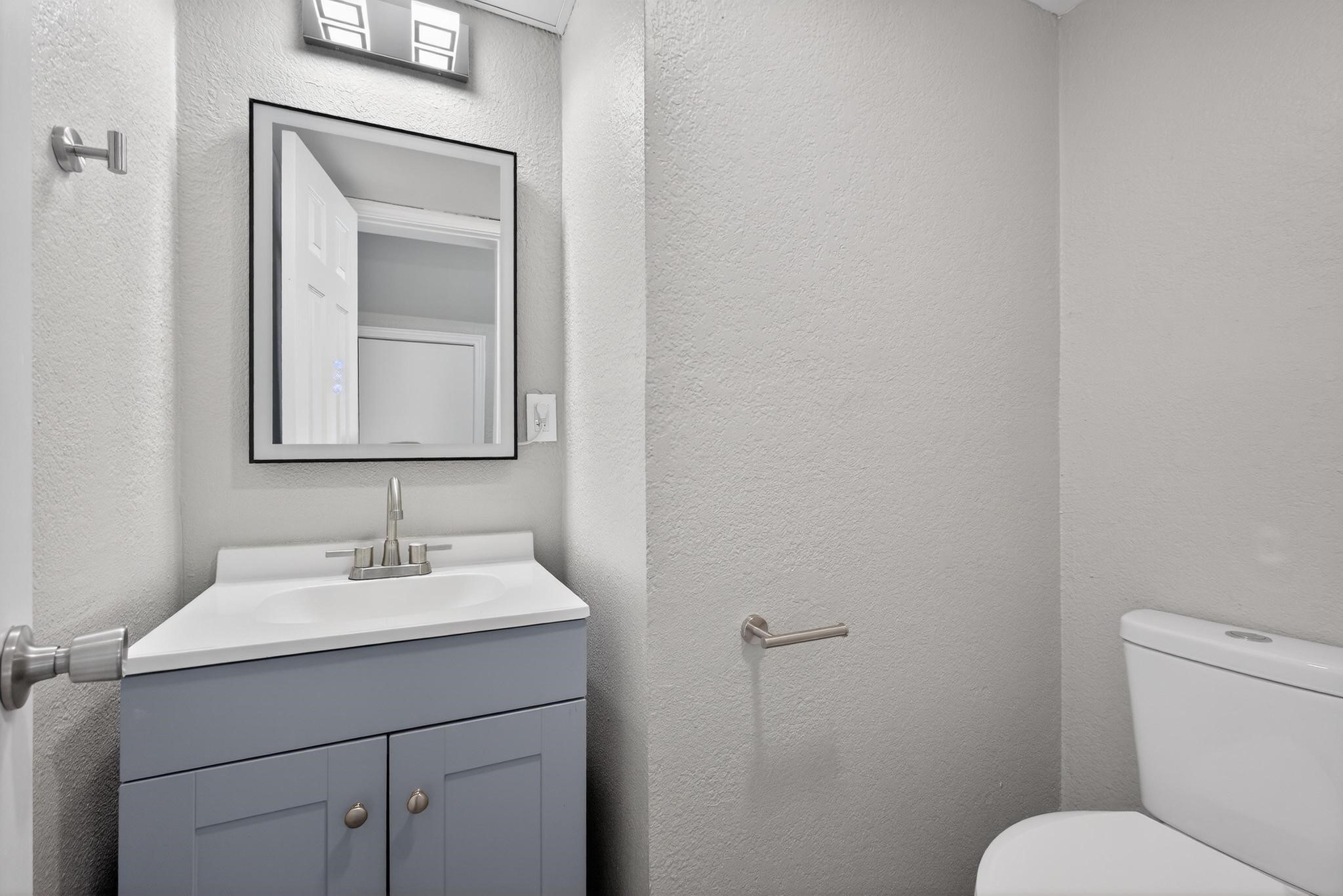 1221 Cedar Post Lane, Unit 4B Houston, TX 77055 - Photo 11 of 16 a bathroom with a toilet sink and mirror