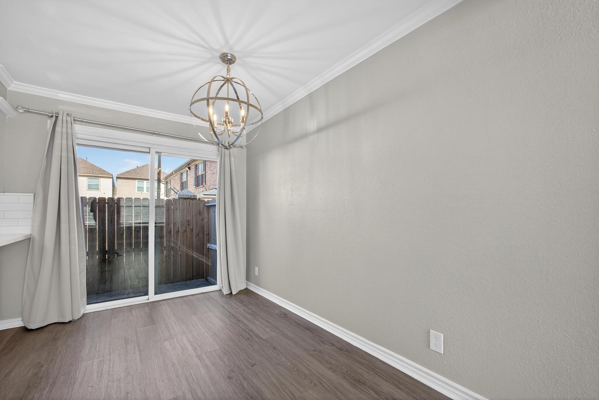 1221 Cedar Post Lane, Unit 4B Houston, TX 77055 - Photo 5 of 16 a view of a hallway with wooden floor and a chandelier