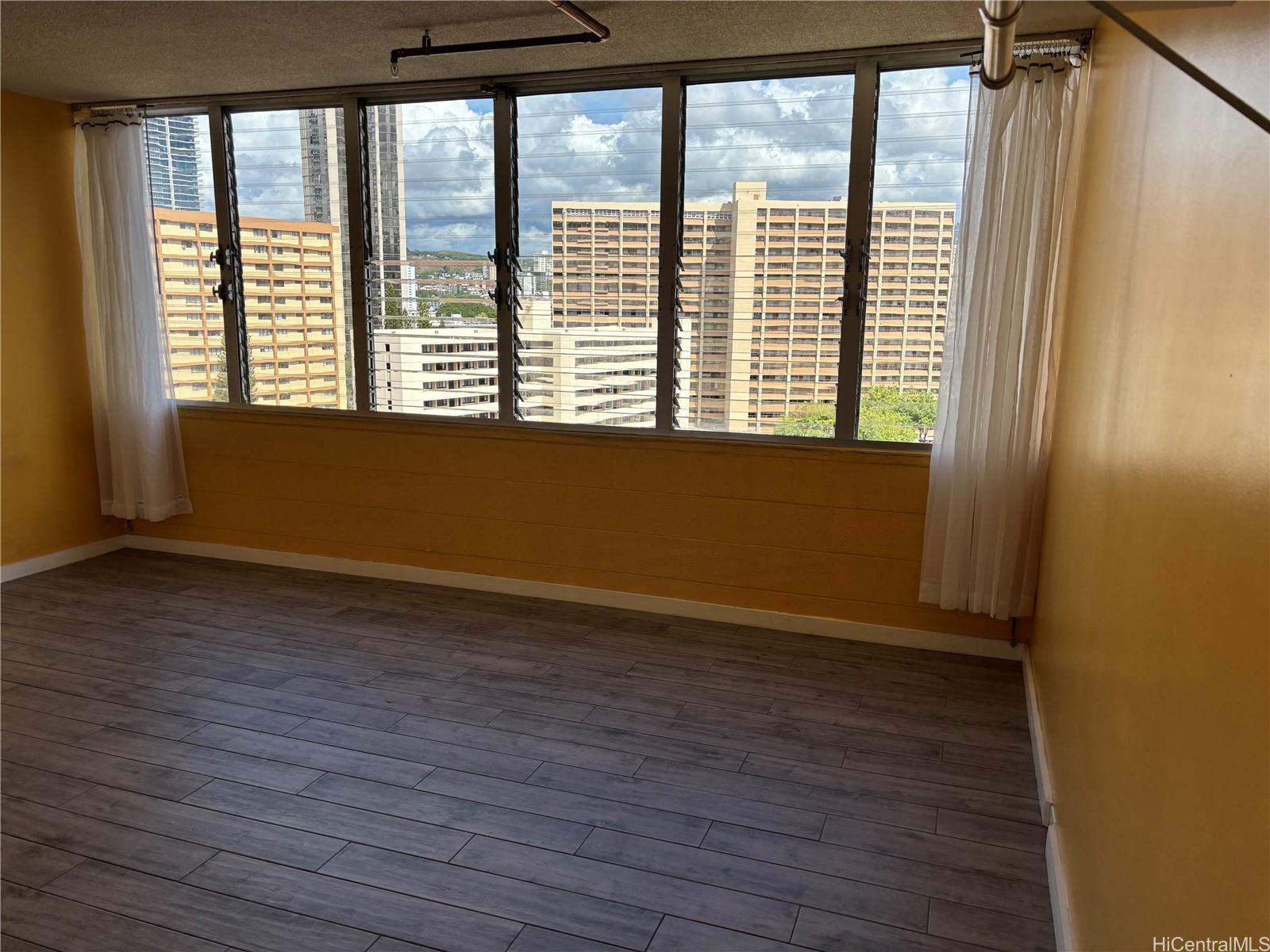 1650 Kanunu Street, Unit 1316 Honolulu, HI 96814 - Photo 4 of 5 a view of an empty room with wooden floor and a window