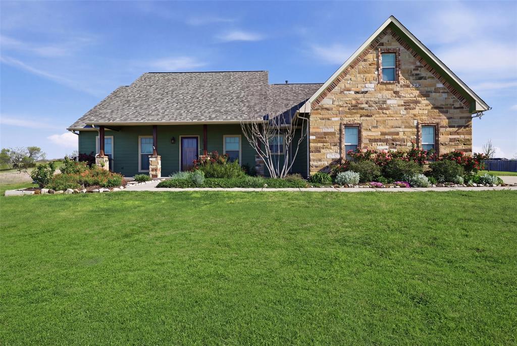 a front view of a house with a yard potted plants and more windows