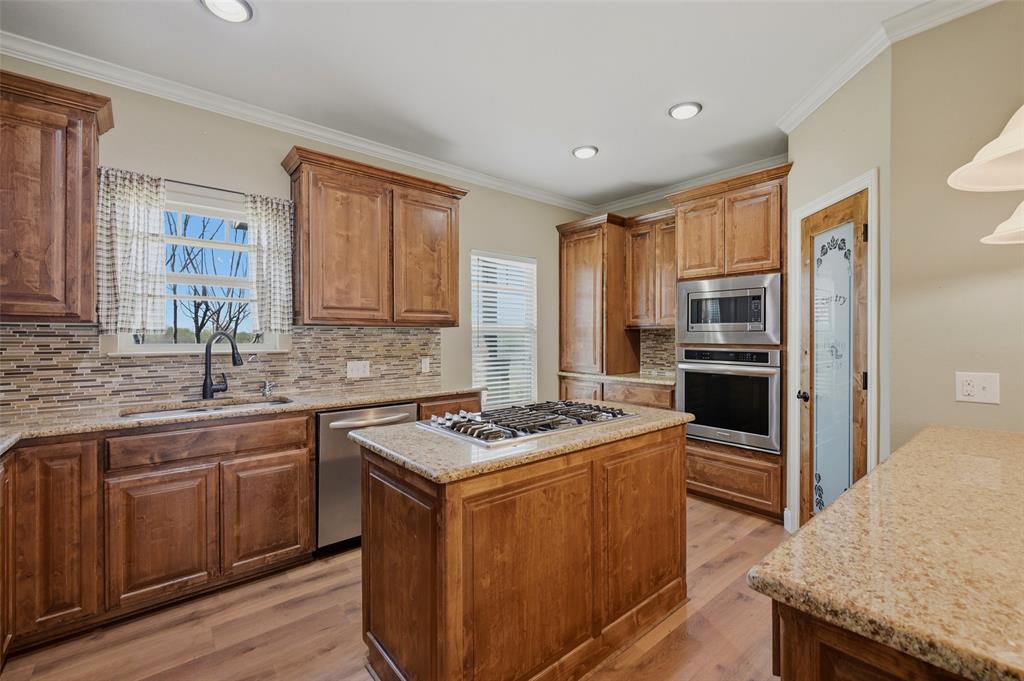 785 Schneider Road Howe, TX 75459 - Photo 12 of 40 a kitchen with stainless steel appliances granite countertop a stove a sink dishwasher a refrigerator and a oven with wooden floor
