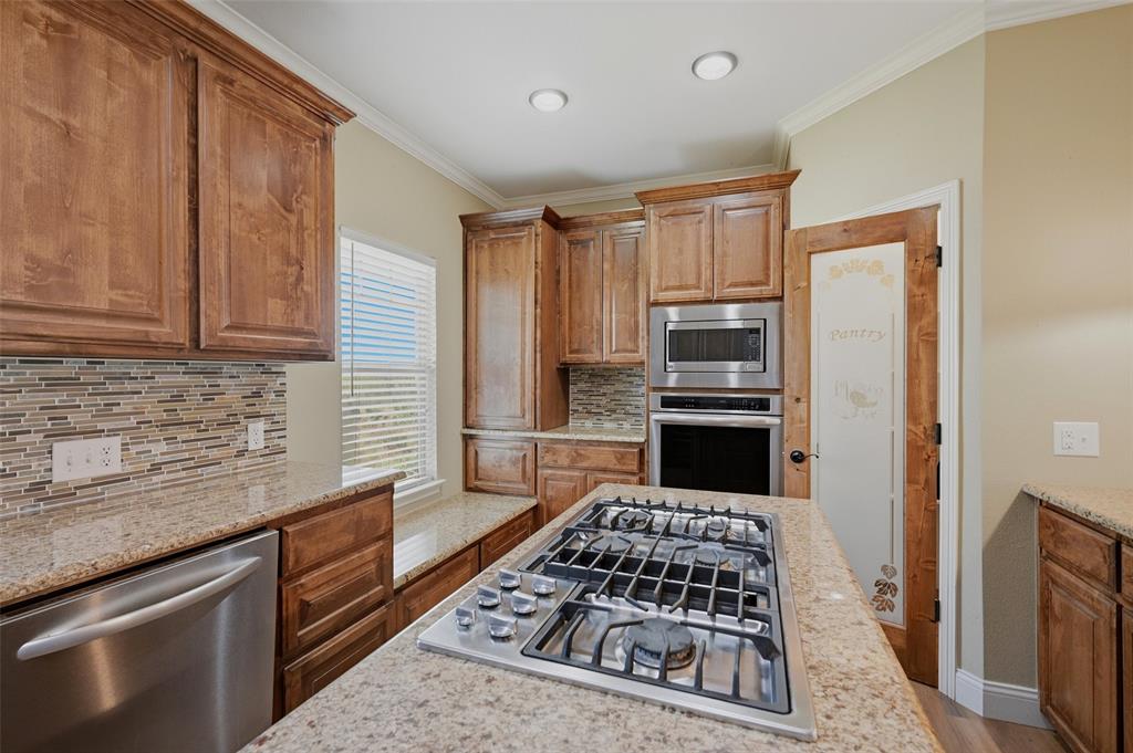 785 Schneider Road Howe, TX 75459 - Photo 13 of 40 a kitchen with granite countertop a stove and a refrigerator