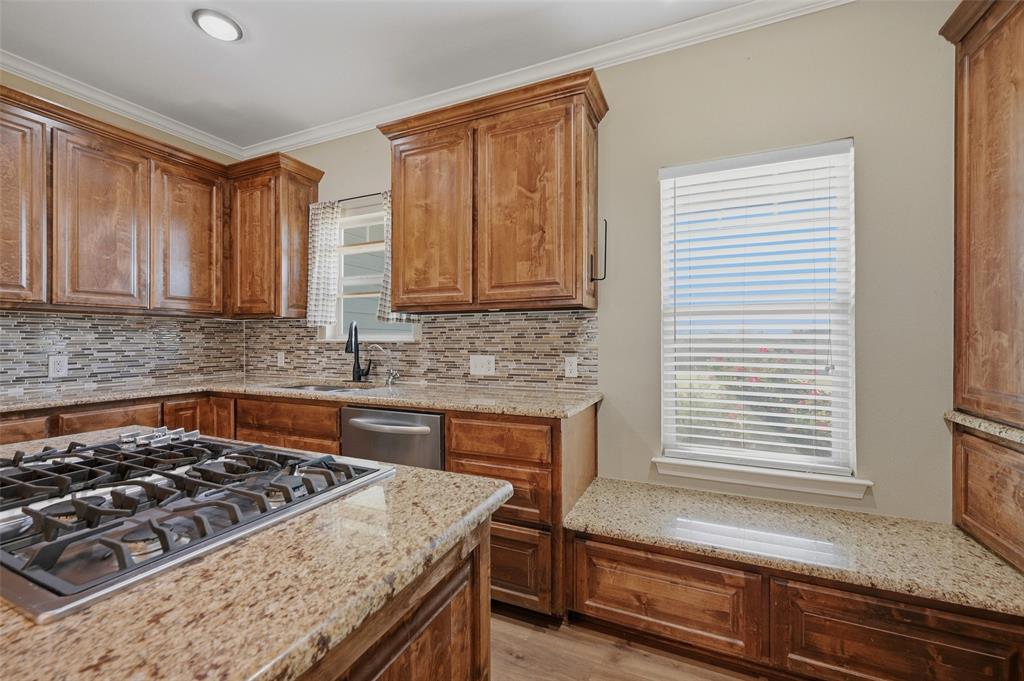 785 Schneider Road Howe, TX 75459 - Photo 16 of 40 a kitchen with granite countertop a stove and a sink