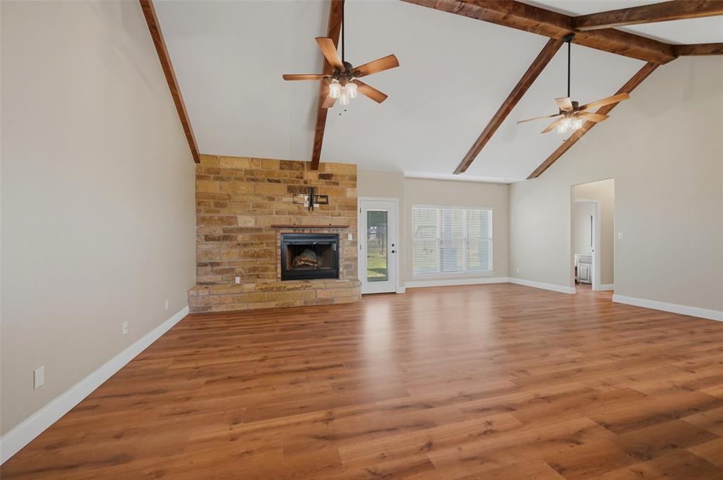 785 Schneider Road Howe, TX 75459 - Photo 5 of 40 a view of an empty room with wooden floor fireplace and a window