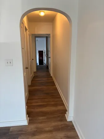 a view of a hallway with wooden floor and staircase