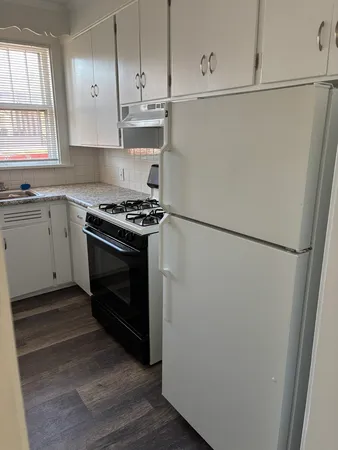 a kitchen with a stove a refrigerator and a window