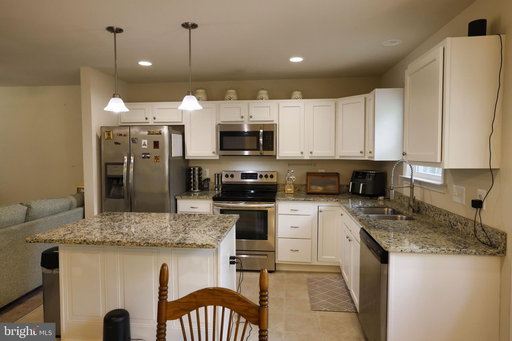 48 Rustic Lane Colonial Beach, VA 22443 - Photo 16 of 47 a kitchen with kitchen island granite countertop a stove a sink a oven a dining table and chairs