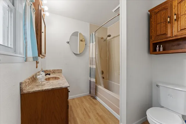 a bathroom with a sink vanity mirror bathtub shower and toilet