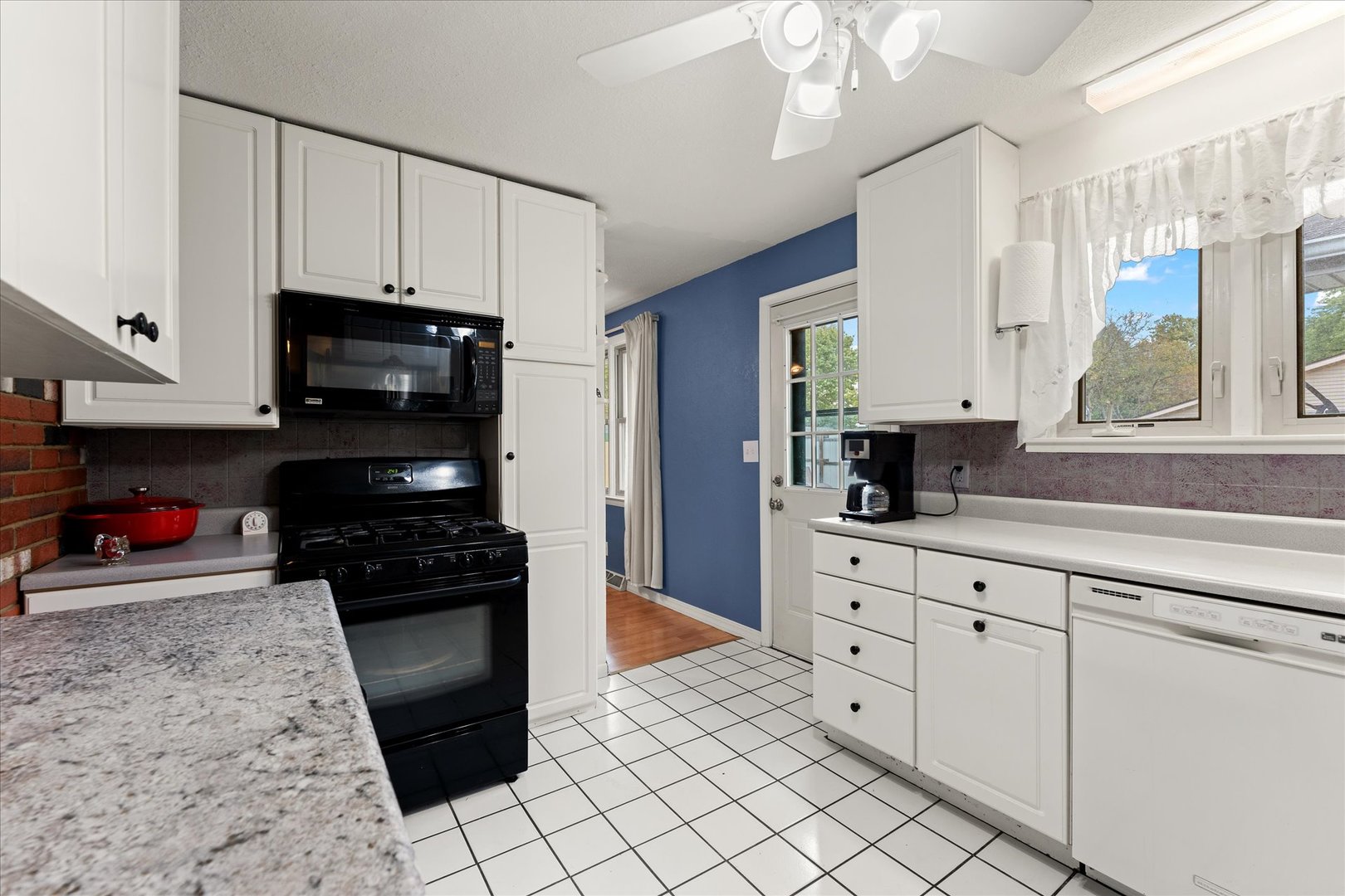 102 North Condit Street Tolono, IL 61880 - Photo 21 of 35 a kitchen with stainless steel appliances kitchen island granite countertop a stove a sink and a microwave