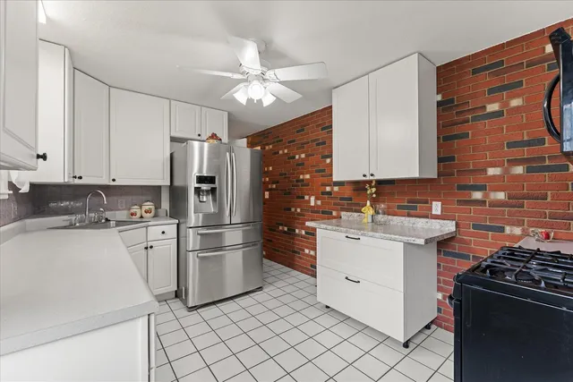a kitchen with white cabinets and appliances