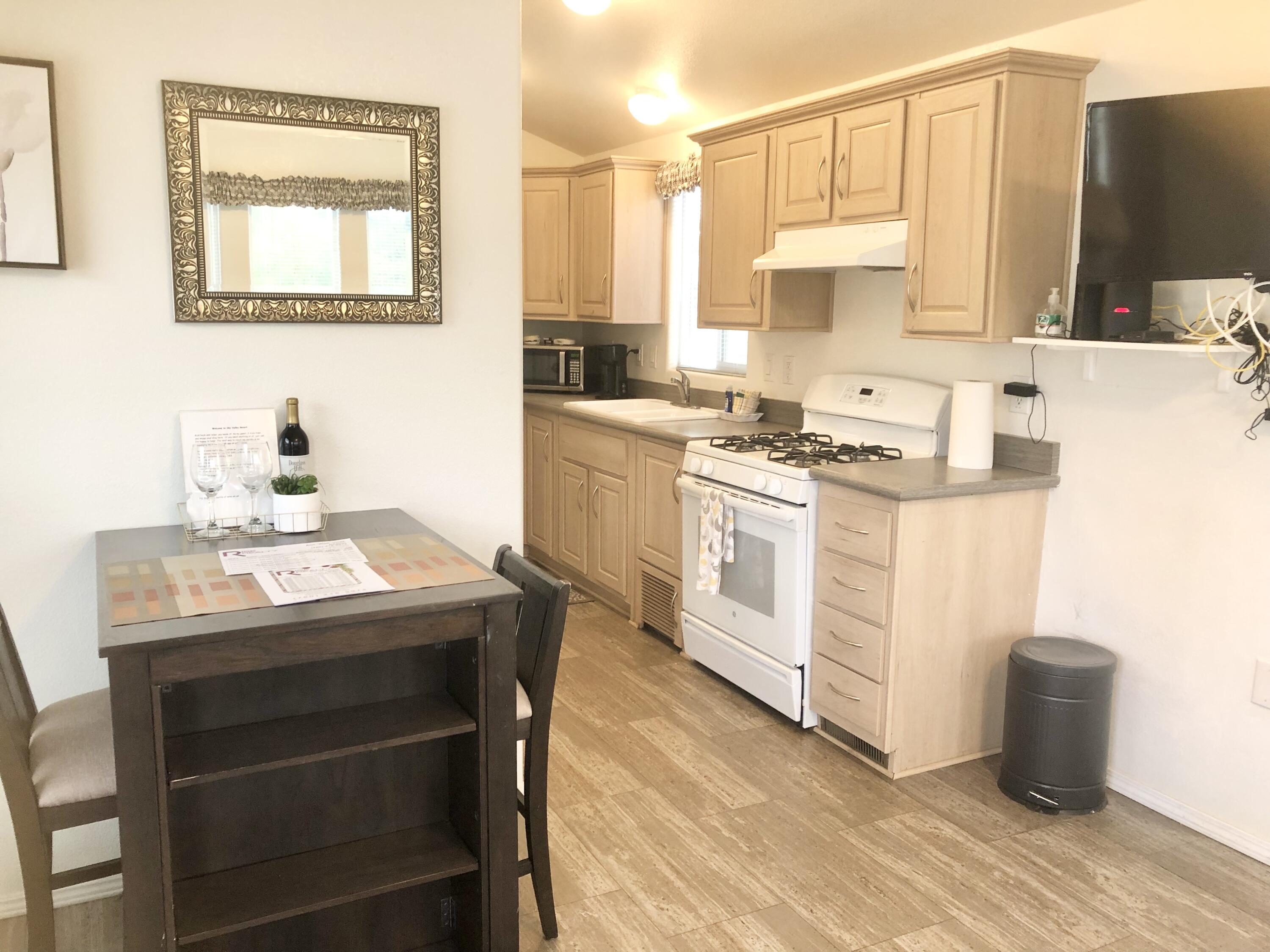 74711 Dillon Road Desert Hot Springs, CA 92241 - Photo 4 of 41 a kitchen with stainless steel appliances a stove a sink and white cabinets